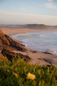 Breathtaking coastal view with waves crashing on rocks at sunset. Perfect for beach lovers.