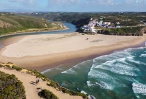 A breathtaking aerial shot of Praia de Odeceixe with its picturesque coastline and vibrant village.