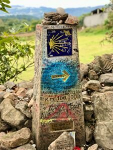 Stone milestone with Camino de Santiago sign in Paradela, Spain.