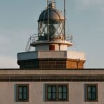 pexels-photo-4852356-4852356 Aged house facade with beacon made of brick with fenced metal observation deck under sky